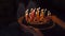 Birthday surprise cake with candles in darkness