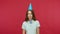 Birthday surprise. Happy young brunette woman in polo t-shirt and funny cone on