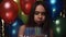 Birthday. Woman Blowing Candles On Cake With Balloons At Party