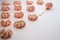 Biscuit pastry on a golden dessert plate near rows of the same sweets on a pink background