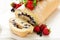 Biscuit roll with mascarpone cream and blueberries decorated strawberries, blueberries and mint leaves