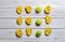 Biscuit rolls with apricot jam and green apples arranged in rows on a white rustic wooden table