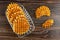 Biscuit wafers in transparent plate, broken wafer on wooden table. Top view