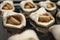 Biscuits filled with apple slices, sugar and cinnamon in pan before baking