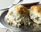 Biscuits and gravy on a silver plate. Southern style sausage gravy on buttermilk biscuits, close view.