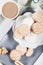 Biscuits on gray plate with cups of coffee, top view