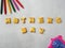 Biscuits, letters, shapes and colorful crayons,plastic toys arranged on a white background for Mother`s Day