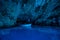 Bisevo, Croatia - Aug 16, 2020: Tourists on a boat in enter serene blue cave near Komiza island