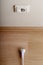 A bit more. White power socket on beige wall at low height from the floor and a short cable