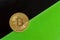 Bitcoin on the background of black and green sheets of paper laid diagonally. The concept of rising value and appreciation of