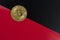 Bitcoin on the background of black and red sheets of paper stacked along the diagonal. The concept of falling value and