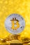 Bitcoin with bit symbol on top of gold coin stack