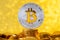 Bitcoin with bit symbol on top of gold coin stack with shiny golden lights background