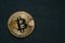 Bitcoin business concept, golden coin - symbol of Bitcoin on black textured background