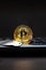 Bitcoin coin on a hook over the keyboard. Cryptology scam concept