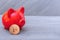 Bitcoin coin and red piggy bank on a gray background, close-up, copy space. Cryptocurrency saving concept