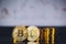 Bitcoin coins pile and two bit coins sitting in front with candle stick graph chart digital background.