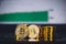 Bitcoin coins pile and two bit coins sitting in front with market spiking and turning green graph chart digital background