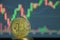 Bitcoin coins are placed on a candlestick background