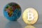 Bitcoin concept. World economy concept. New world currency.Golden coin bitcoin and globe.