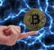 Bitcoin cryptocurrency coin balancing on a finger with blue electricity background