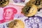 Bitcoin cryptocurrency coins on China Yuan Renminbi currency and North Korean Won banknotes close up image.