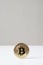 Bitcoin cryptocurrency physical coin standing upright on desk