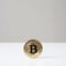 Bitcoin cryptocurrency physical coin standing upright on desk