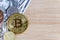 Bitcoin and foreign currency coins on wooden table background.