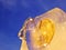 Bitcoin gold coin frozen in half in a piece of ice on a blue background. The freezing of financial assets. The fall of