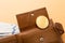 Bitcoin, hundred dollar bills and leather wallet on the orange background