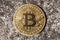 Bitcoin logo, round metal gold crypto coin, cryptocurrency representative symbol on concrete background, closeup