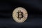 Bitcoin physical coin symbol on black background