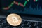 Bitcoin physical coin symbol on laptop with uptrend price graph background, future concept financial currency