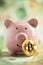 Bitcoin on piles of money leaning on pink piggy bank. Wealth, savings, digital, virtual, currency, and cryptocurrency