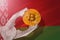 Bitcoin regulation in Belarus; bitcoin btc coin being squeezed in vice on Belarus flag background