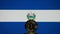 Bitcoin representation coin placed in front of blurred Salvador\'s national flag.