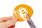 Bitcoin symbol being cut in half with scissors held in human hand, fall of digital currency Bitcoin prices, halving