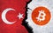 Bitcoin and Turkey flag on a wall with a crack.