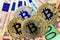 Bitcoin virtual coins on euros banknotes. Closeup, macro shot