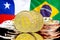 Bitcoins on Chile and Brazil flag background