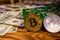 Bitcoins, circuit board and one hundred dollar bills on a wooden table