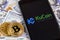 Bitcoins, dollars and KuCoin logo on the screen smartphone