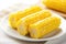 bite marks on a butter glazed sweet corn on a white plate