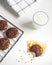 bited dark chocolate cookies on baking tray serving with a glass of milk. concept of delicious homemade dessert or snack good for