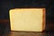 Bitesize Slice of smoked cheddar cheese on rustic wooden background