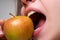 Biting an apple. Mouth close up. Woman eating apple, natural lips.