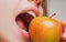 Biting an apple. Mouth close up. Woman eating apple, natural lips.