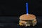 Bitten burger with a candle