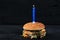 Bitten burger with a candle with fire